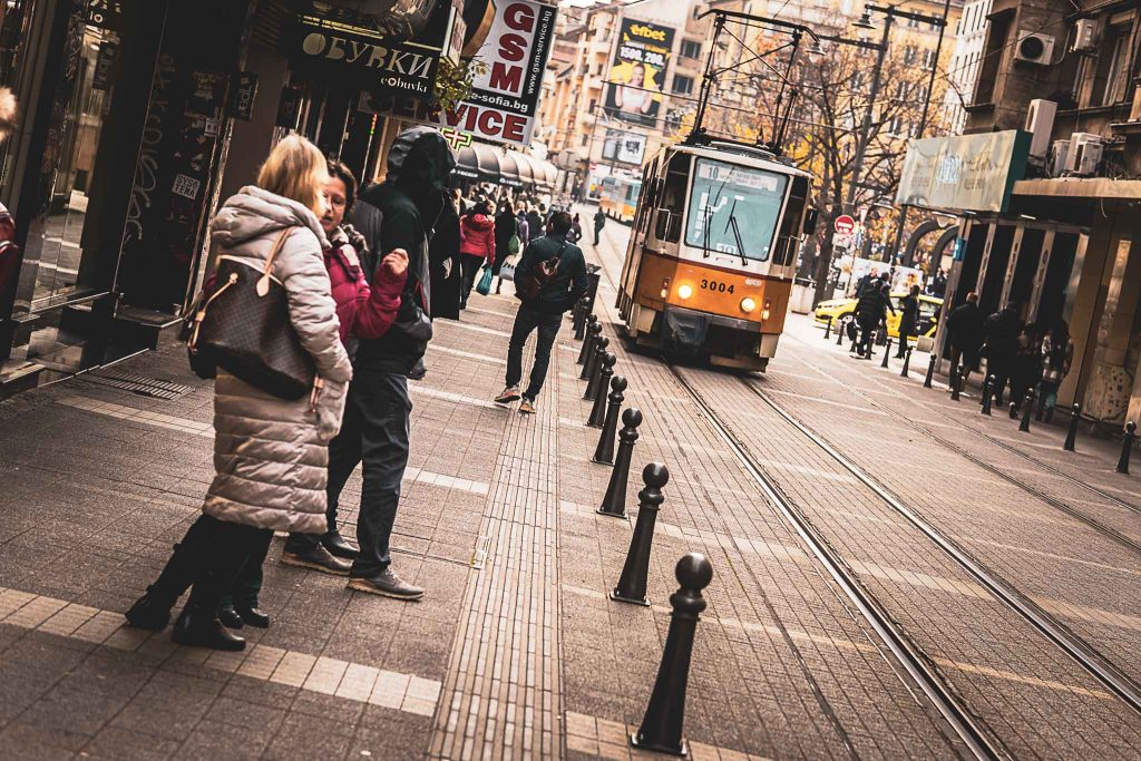 Street scene with people and a passing tram on Graf Ignatiev Street, in central Sofia, Bulgaria.