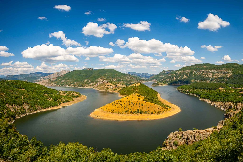 A wide horseshoe-shaped curve in the Arda River, surrounded by forests and mountain slopes.